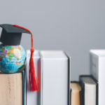 A miniature Globe with a Graduation Cap atop of books showing Higher education